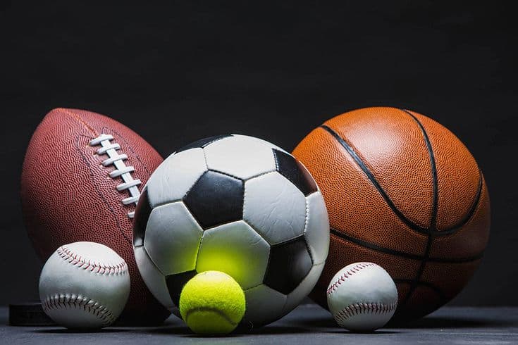 Balones de fútbol, baloncesto, fútbol americano, béisbol y tenis sobre un fondo oscuro.